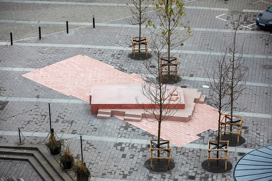 Monumentet tar stor plats på Esperantoplatsen och breder ut sig som en rosa yta. Det ramas in av fem träd, som just nu är små men som kommer växa till sig.